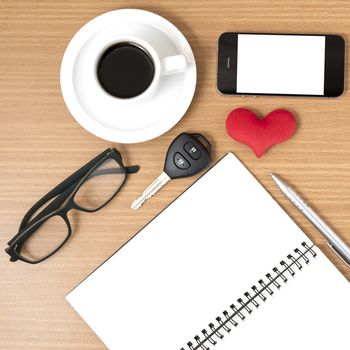 office desk : coffee and phone with car key,eyeglasses,notepad,heart on wood background