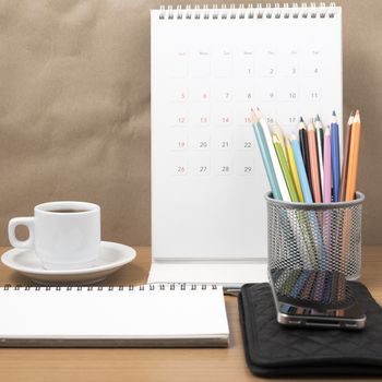 office desk : coffee with phone,wallet,calendar,color pencil box,notepad on wood background