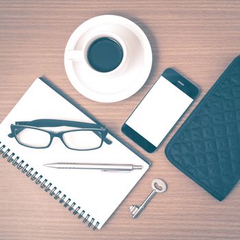 coffee and phone with notepad,key,eyeglasses and wallet on wood table background vintage style