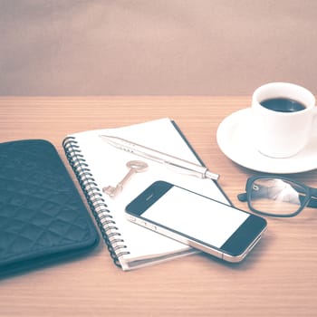 coffee and phone with notepad,key,eyeglasses and wallet on wood table background vintage style