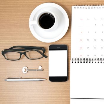 coffee and phone with key,eyeglasses,notepad,calendar on wood table background