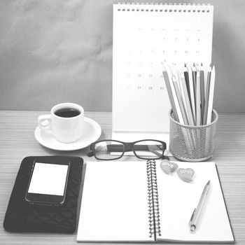 office desk : coffee with phone,wallet,calendar,color pencil box,notepad,heart on wood background black and white color