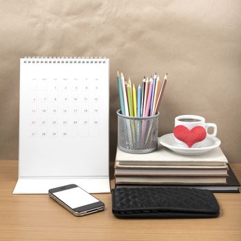 office desk : coffee with phone,wallet,calendar,heart,color pencil box,stack of book,heart on wood background