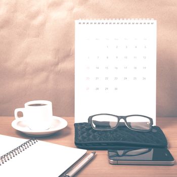 office desk : coffee with phone,calendar,wallet,notepad on wood background vintage style