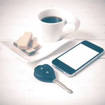 coffee cup with wafer,phone,car key on white wood background vintage style