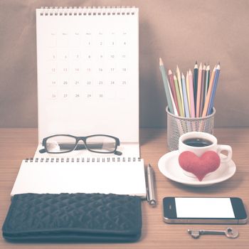 office desk : coffee with phone,wallet,calendar,heart,notepad,eyeglasses,color pencil box,key on wood background vintage style
