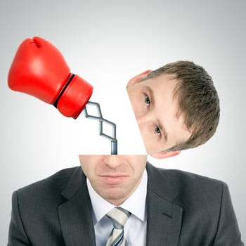 Boxing glove beating from businessmans head on grey background, front view