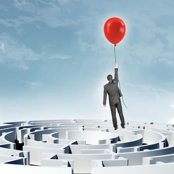 Businessman flying up with balloon above labyrinth