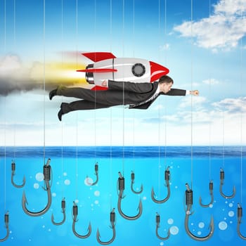 Businessman flying with rocket above ocean with fishhooks