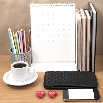 office desk : coffee with phone,wallet,calendar,heart,color pencil box,stack of book,heart on wood background