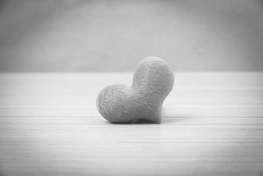 red heart on wood table background black and white color