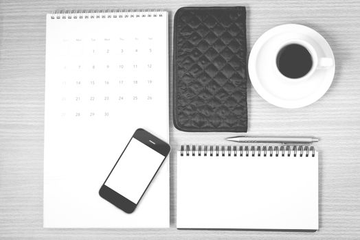 desktop : coffee with phone,notepad,wallet,calendar on wood background black and white color