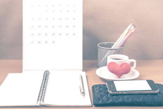 office desk : coffee with phone,wallet,calendar,heart,color pencil box,notepad,heart on wood background vintage style