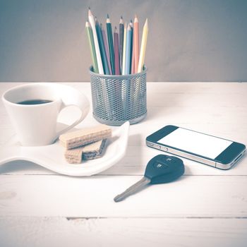 coffee cup with wafer,phone,pencil box,car key on white wood background vintage style