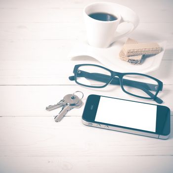 coffee cup with wafer,phone,key,eyeglasses on white wood background vintage style