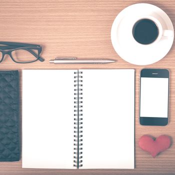 office desk : coffee with phone,notepad,eyeglasses,wallet,heart on wood background vintage style