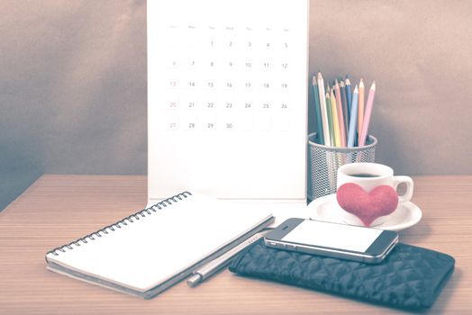 office desk : coffee with phone,wallet,calendar,heart,color pencil box,notepad,heart on wood background vintage style