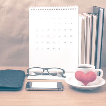 desktop : coffee with phone,stack of book,wallet,heart,eyeglasses,calendar on wood background vintage style