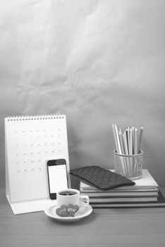 office desk : coffee with phone,wallet,calendar,heart,color pencil box,stack of book,heart on wood background black and white color