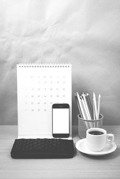 office desk : coffee with phone,calendar,wallet,color pencil on wood background black and white color