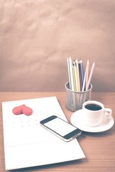 office desk : coffee with phone,calendar,heart on wood background vintage style