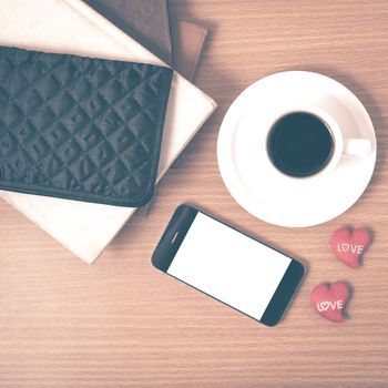 office desk : coffee with phone,stack of book,wallet on wood background vintage style