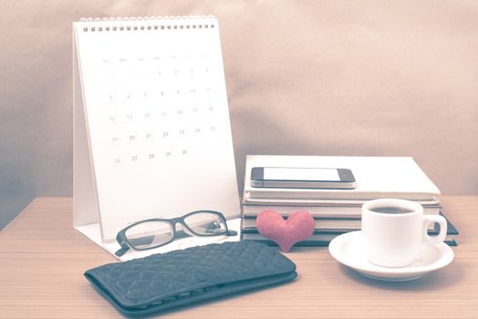 desktop : coffee with phone,stack of book,wallet,heart,eyeglasses,calendar on wood background vintage style