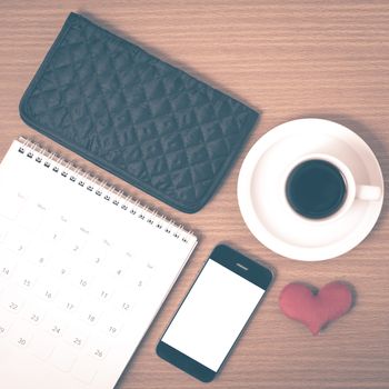 office desk : coffee with phone,wallet,calendar,heart on wood background vintage style