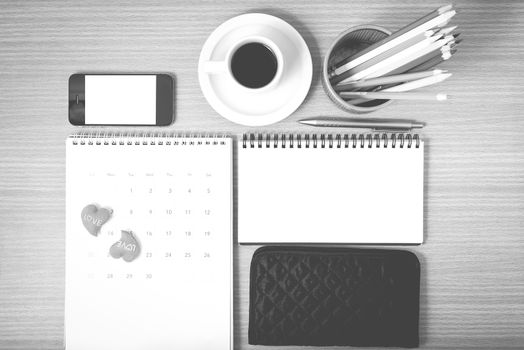 office desk : coffee with phone,wallet,calendar,heart,color pencil box,notepad on wood background black and white color