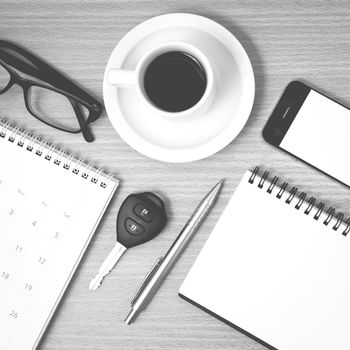 coffee and phone with car key,eyeglasses,notepad,calendar on wood background black and white color