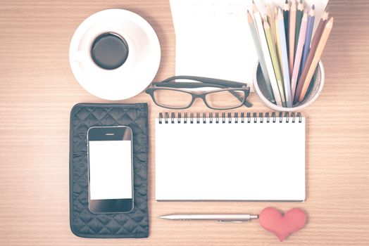 office desk : coffee with phone,wallet,calendar,color pencil box,notepad,heart on wood background vintage style