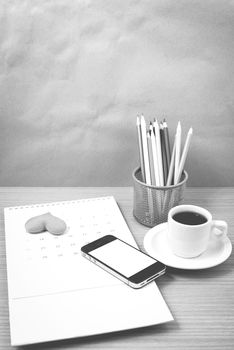 office desk : coffee with phone,calendar,heart on wood background black and white color