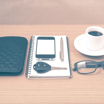 coffee and phone with notepad,car key,eyeglasses and wallet on wood table background vintage style