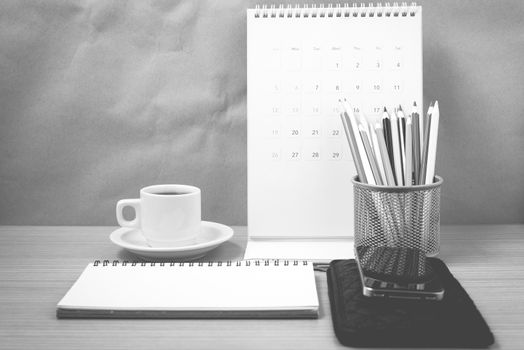 office desk : coffee with phone,wallet,calendar,color pencil box,notepad on wood background black and white color