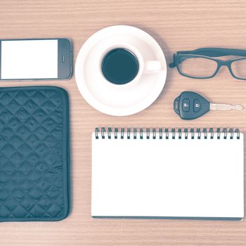 coffee and phone with notepad,car key,eyeglasses and wallet on wood table background vintage style