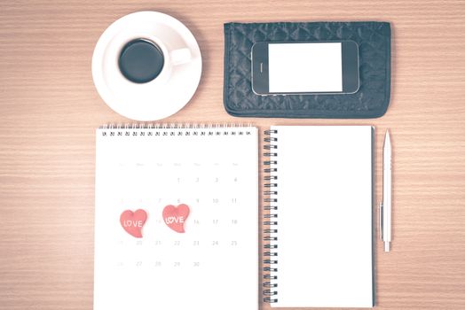 office desk : coffee with phone,wallet,calendar,heart,notepad on wood background vintage style