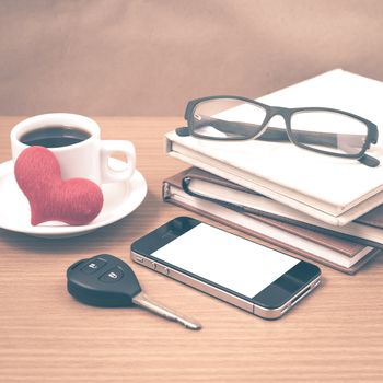 office desk : coffee and phone with car key,eyeglasses,stack of book,heart vintage style