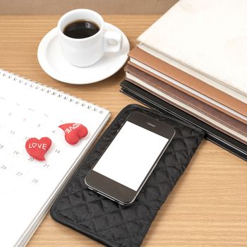 office desk : coffee with phone,wallet,calendar,heart,stack of book on wood background