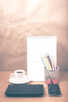 office desk : coffee with phone,wallet,calendar,heart,color pencil box on wood background vintage style