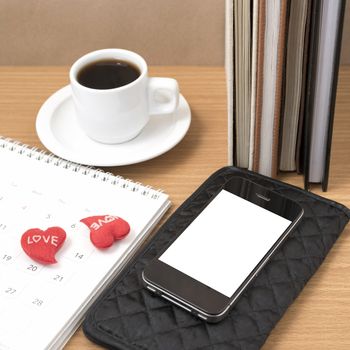 office desk : coffee with phone,wallet,calendar,heart,stack of book on wood background