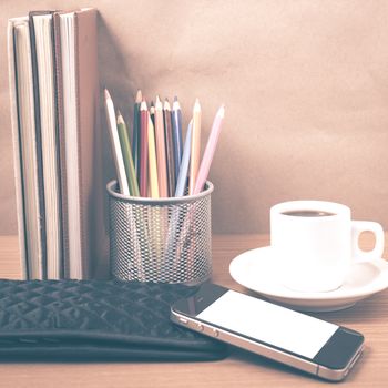 office desk : coffee with phone,stack of book,wallet,color box on wood background vintage style