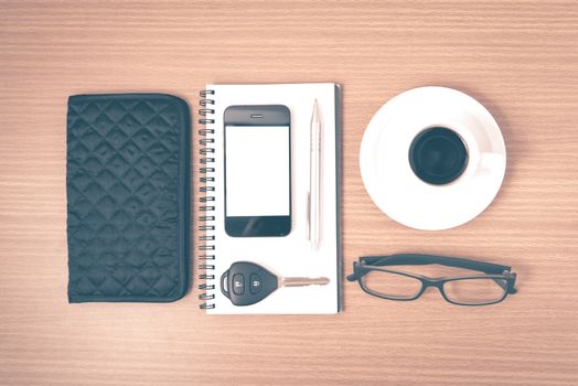 coffee and phone with notepad,car key,eyeglasses and wallet on wood table background vintage style