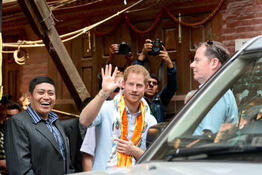 NEPAL, Kathmandu : Britain's Prince Harry (C) waves as he walks with officials as he visits heritage sites in Patan Durbar Square on the outskirts of Kathmandu on March 20, 2016. Britain's Prince Harry arrived in Nepal for a five-day visit and said he hopes to shine a spotlight on resilience of Nepali people recovering from last year's devastating quake. 