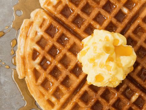 close up of rustic traditional waffle with butter and maple syrup