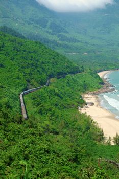 Panorama scene of Lang Co beach, Hue from Hai Van mountain pass at Da Nang, Viet Nam. Amazing landscape of train moving on railway at seaside, nice view of nature with green forest, wave on sea