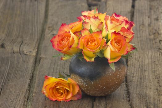 roses in a vase on wooden background