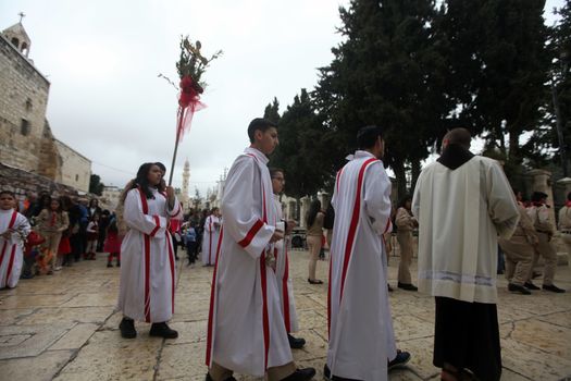 WEST BANK, Bethlehem: Palestinian Catholics walk to the Church of the Nativity Compound, to celebrate the Palm Sunday on March 20, 2016 in the West Bank city of Bethlehem. Palm Sunday marks the triumphant return of Jesus Christ to Jerusalem when a cheering crowd greeted him waving palm leaves, a week before his crucifixion.