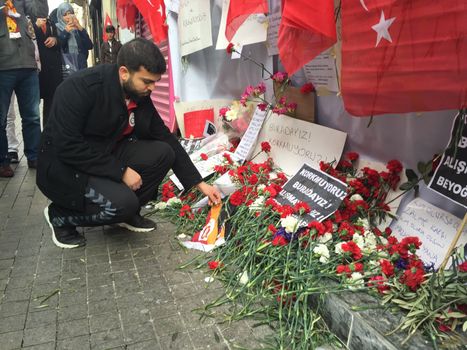 TURKEY, Istanbul: A man drops off a flower at the site of a blast on Istiklal Street, a major shopping and tourist district, in central Istanbul on March 20, 2016 in tribute to four people killed during a suicide blast that ripped through Istanbul less than a week after another deadly attack left 35 dead in Ankara.
