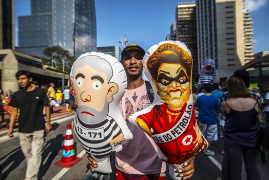 BRAZIL, Sao Paulo: A demonstrator holds balloon representing President Dilma Rousseff and former President Lula as thousands of protesters demonstrate against Brazilian former president (2003-2011) Luiz Inacio Lula da Silva in Sao Paulo, on March 20, 2016. Brazilian lawmakers relaunched impeachment proceedings against President Dilma Rousseff Thursday and a judge blocked her bid to bring her powerful predecessor into her cabinet, intensifying the political crisis engulfing her.