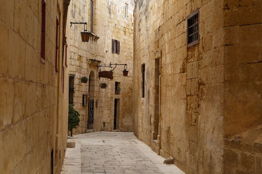MDINA, MALTA - NOVEMBER 1, 2015 : View of narrow Mdina streets with limestone historical buildings around.